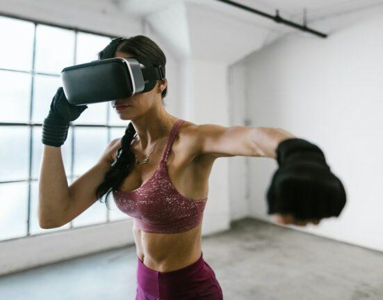 A person immersed in a virtual reality workout surrounded by digital elements